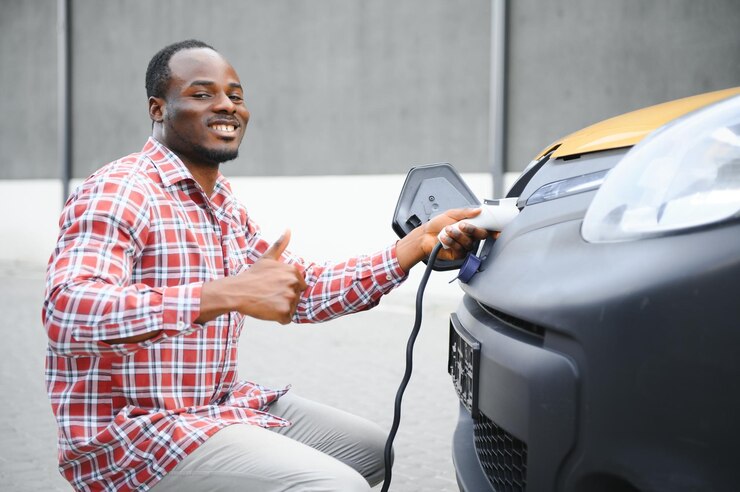 Un Afro-Américain charge sa voiture électrique.