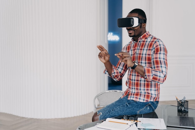 Un afro-américain dans des lunettes VR interagit avec la réalité virtuelle augmentée pour faire du commerce électronique