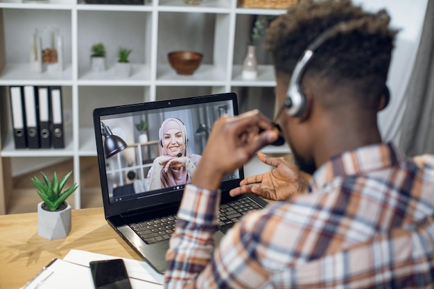 Afro-américain et femme musulmane ayant un appel vidéo