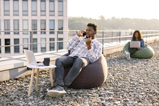 Un Afro-Américain insouciant en tenue décontractée fait un appel téléphonique.