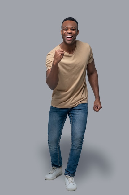 Afro-américain. Photo de studio d'un homme à la peau foncée dans un t-shirt beige