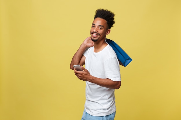 Afro-américain avec sac à provisions et tasse de café à emporter.