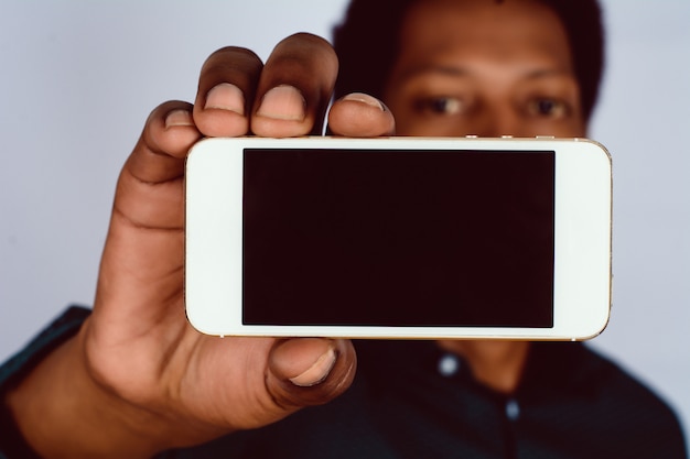 Afro-américain tenant un smartphone.