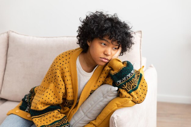 Afro-américain triste réfléchie pensive fille non motivée assise sur un canapé à la maison jeune afrique intérieure