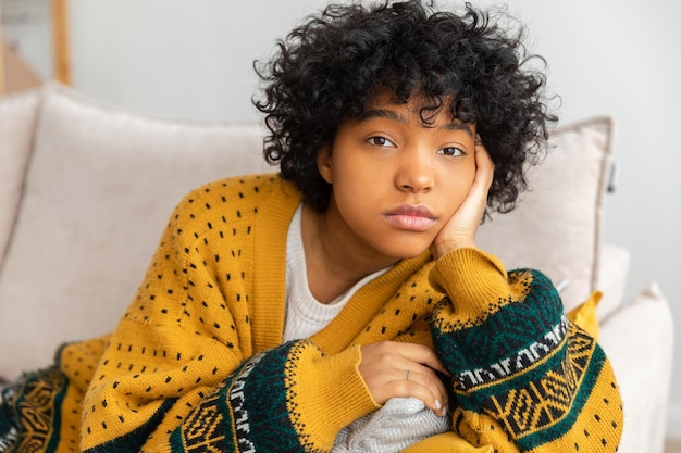 Afro-américain triste réfléchie pensive fille non motivée assise sur un canapé à la maison jeune afrique intérieure