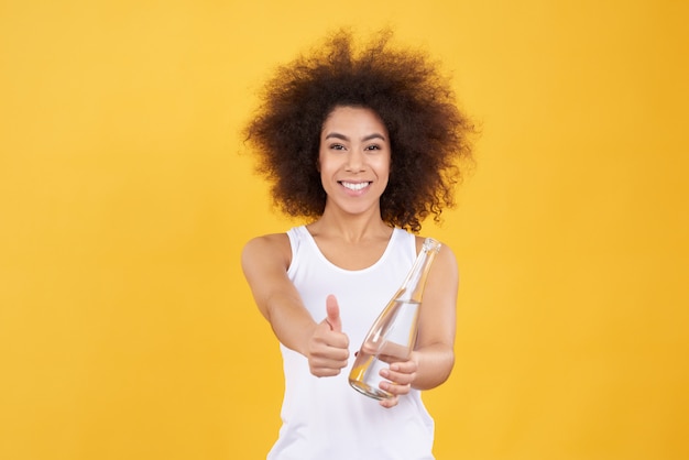 Afro-américaine pose avec de l&#39;eau isolée.