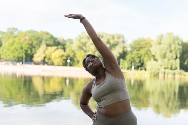 Une Afro-Américaine de taille plus grande faisant de l'exercice dans le parc par une journée d'été.