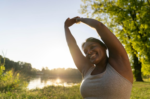 Une Afro-Américaine de taille plus grande faisant de l'exercice dans le parc par une journée d'été.