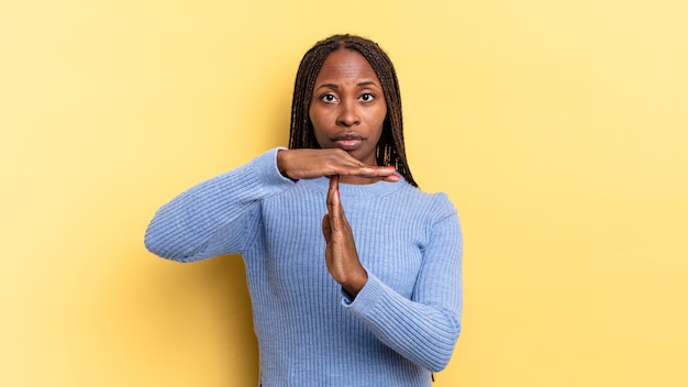 Afro black jolie femme semblant sérieuse, sévère, en colère et mécontente, faisant signe de temps mort