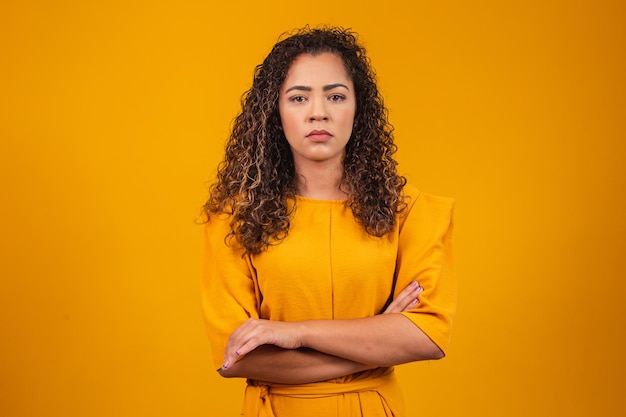 Afro femme avec les bras croisés sur fond jaune