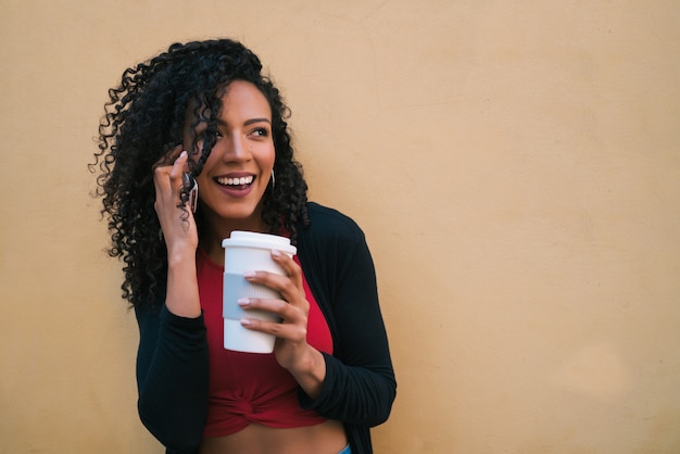 Afro femme parlant au téléphone.