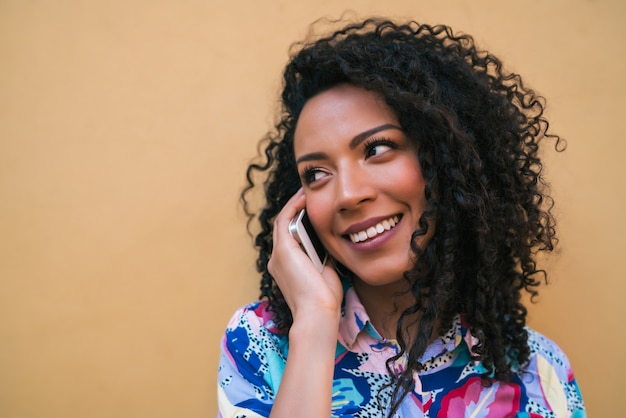 Afro femme parlant au téléphone.