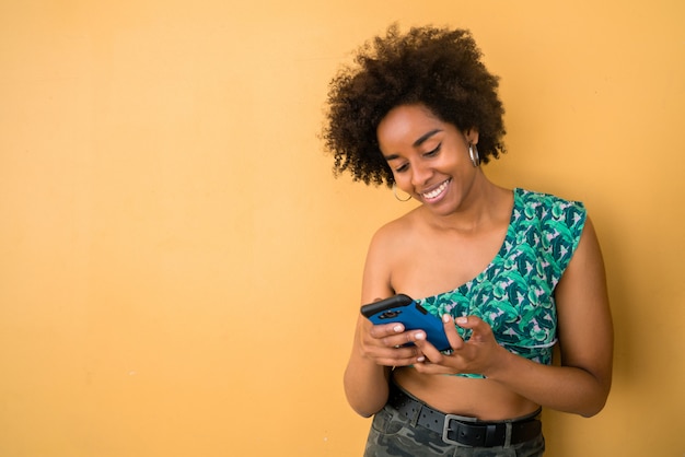 Afro femme utilisant son téléphone portable.