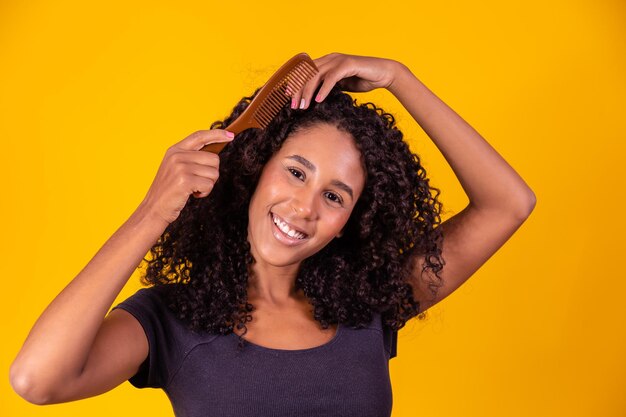 Afro girl peignant ses cheveux avec un peigne