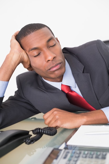 Afro homme d&#39;affaires reposant au bureau sur fond blanc