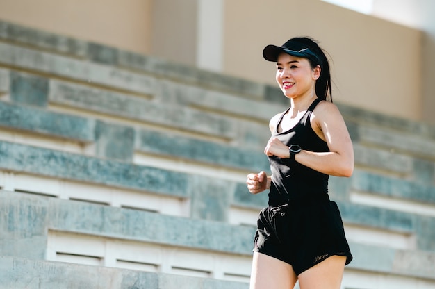 d'âge moyen Belle femme asiatique sportive athlète de coureur en plein air courant sur les escaliers du stade mode de vie actif et sain.