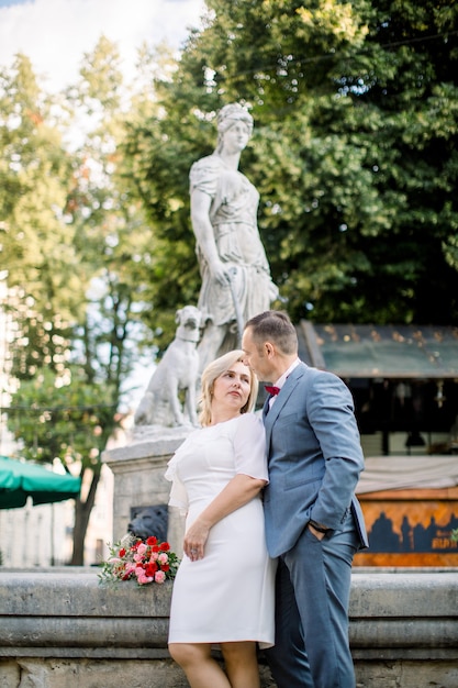 D'âge Mûr S'embrassant Devant Une Fontaine D'eau, Se Regardant Avec Amour