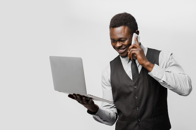 Agence de rencontre en ligne. Un homme noir avec un ordinateur portable et un téléphone parle avec des femmes du monde entier. Homme d'affaires trouvant son amour sur internet.