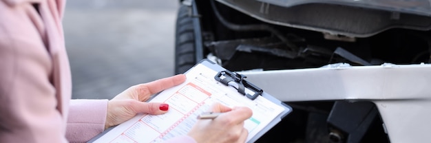 Photo un agent d'assurance décrit les dommages causés à l'indemnisation des véhicules à moteur des réclamations d'assurance après la voiture