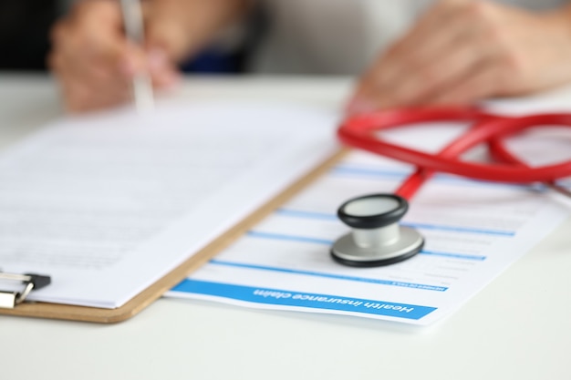 L'agent d'assurance remplit le formulaire d'assurance médicale pour le concept de services médicaux du client