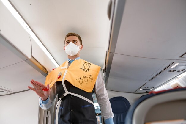Agent de bord démontrant comment utiliser le gilet de sauvetage dans les avions
