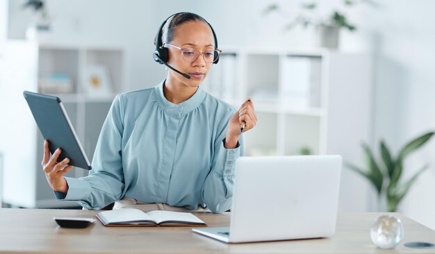 Agent de centre d'appels sérieux et confiant appelant pour aider et assister une transaction ou une vente sur un ordinateur portable et une tablette.