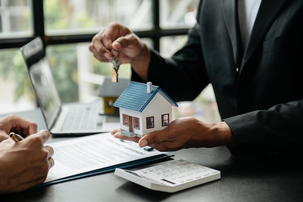 Agent de courtage immobilier présentant et consultant au client pour la prise de décision signe un formulaire d'assurance modèle d'accord de maison concernant l'offre de prêt hypothécaire