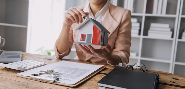 Agent de courtage immobilier présentant et consultant le client pour la prise de décision signant un contrat d'assurance modèle d'achat et de vente de maison concernant l'offre de prêt hypothécaire et l'assurance habitation