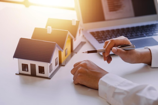 Agent de courtage immobilier présentant et consultant le client pour la prise de décision signant un contrat d'assurance modèle d'achat et de vente de maison concernant l'offre de prêt hypothécaire et l'assurance habitation