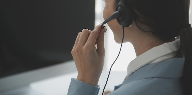 Agent de femme jeune opérateur sympathique avec des casques travaillant dans un centre d'appels