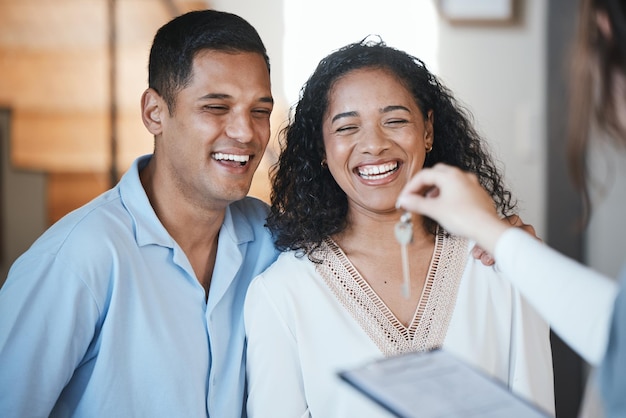 Agent immobilier de clés et couple de propriétaires dans leur appartement après paiement ou investissement dans un bien immobilier Hypothèque ou prêt immobilier avec un homme et une femme recevant la clé de leur nouvelle maison