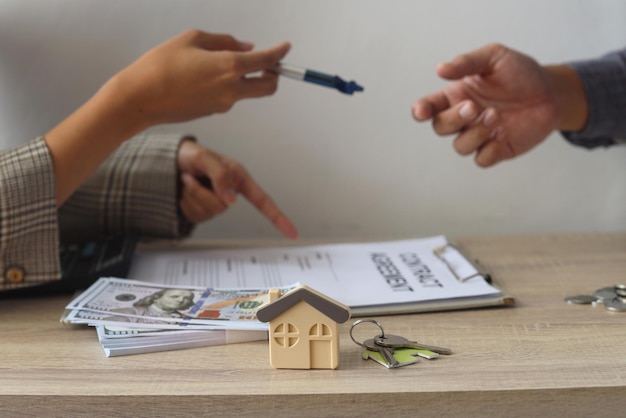 Agent immobilier et client signant un contrat d&#39;achat de maison, d&#39;assurance ou de prêt immobilier.