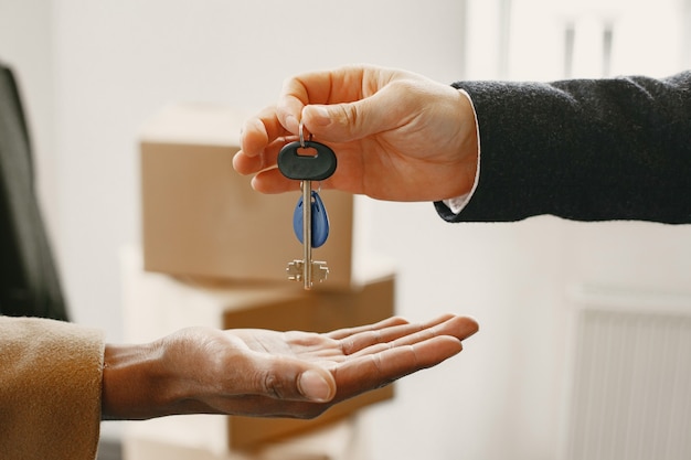 Agent immobilier donnant les clés de l'appartement aux jeunes mariés, couple achetant une maison.