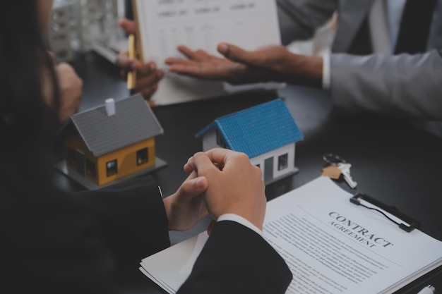 Agent immobilier et équipe de gestionnaire des ventes analyse le prix du contrat de location-bail du contrat de vente-achat concernant l'offre de prêt hypothécaire et l'assurance habitation.