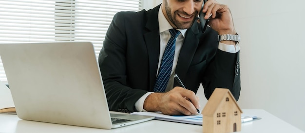 Agent immobilier intelligent professionnel faisant un appel d'affaires parlant sur téléphone portable avec le client pour la signature d'un contrat de bail de location dans un contrat de prêt à domicile de bureau achetant un concept immobilier de maison