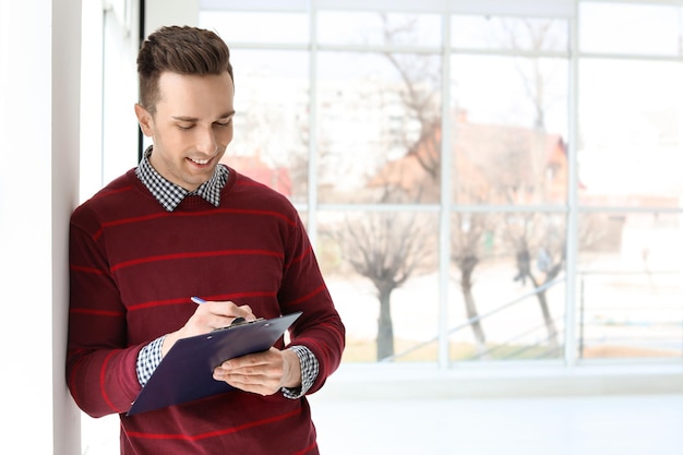 Agent immobilier masculin avec presse-papiers à l'intérieur