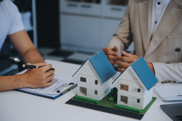 L'agent immobilier a parlé des termes du contrat d'achat de maison et a demandé au client de signer les documents pour rendre le contrat légal Concept de vente de maison et d'assurance maison