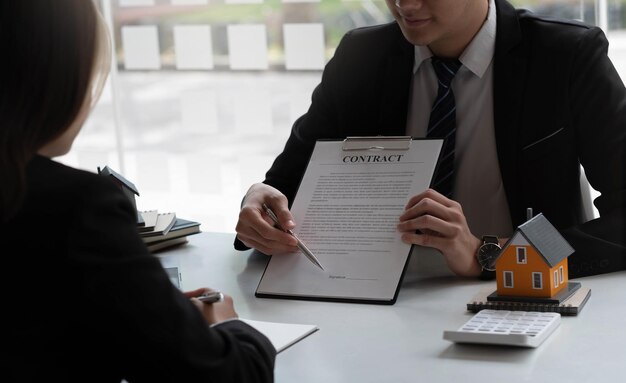 L'agent immobilier pour acheter une maison et un terrain livre la maison au client après avoir accepté de conclure un contrat d'achat de maisonxA