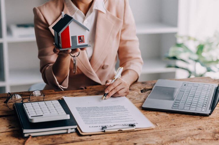 Photo agent immobilier présentant et consultant le client à la prise de décision signer le formulaire d'assurance contrat d'achat et de vente de maison modèle concernant l'offre de prêt hypothécaire et l'assurance habitation
