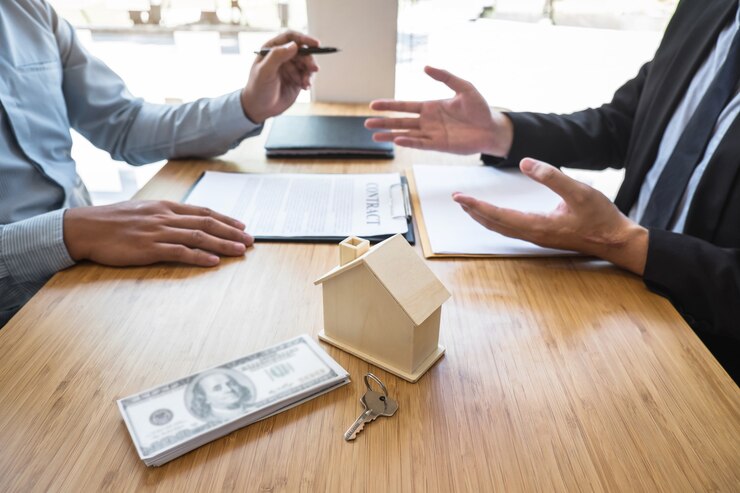 Agent immobilier présentant le prêt immobilier et donnant les clés de la maison au client