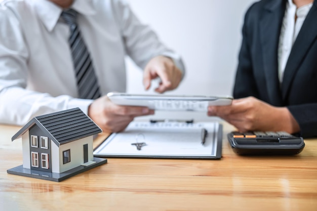 Photo l'agent immobilier présente un prêt immobilier et donne une maison au client après avoir discuté et signé un contrat d'accord avec le formulaire de demande approuvé concept d'assurance habitation et d'investissement immobilier