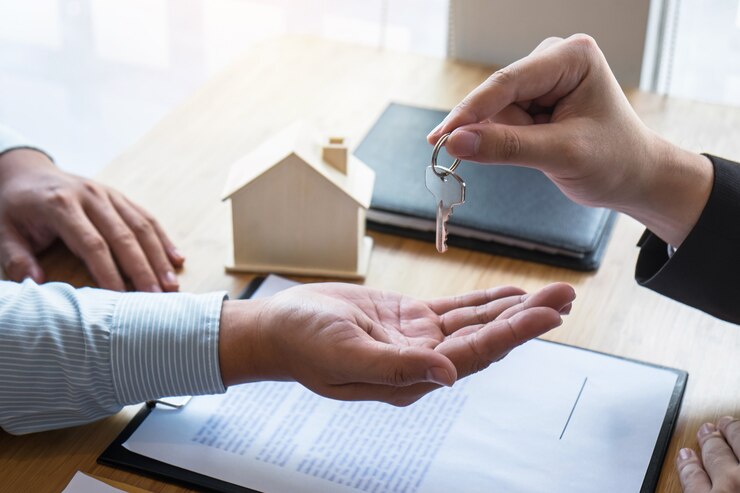 Agent immobilier remettant une clé à un client