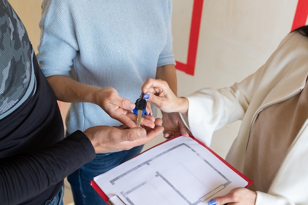 Agent immobilier remettant les clés du nouvel appartement à un jeune couple émotionnel Concept nouvelles maisons nouveau départ