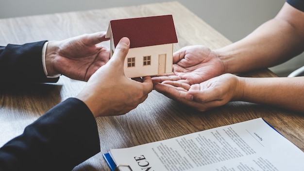 Agent immobilier remettant la maison et les clés au client