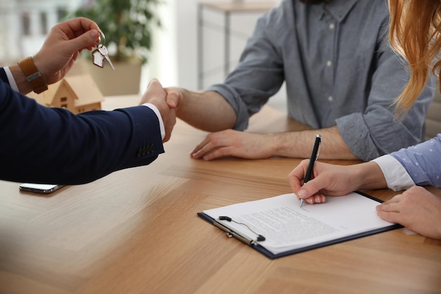 Un agent immobilier travaillant avec des clients dans un bureau en gros plan