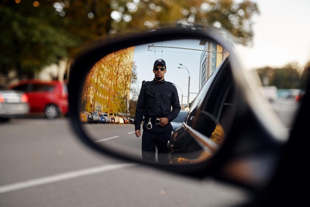 Agent de police, vue à travers le rétroviseur de voiture