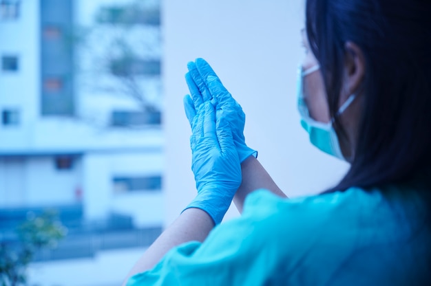 Agent de santé applaudissant depuis le balcon