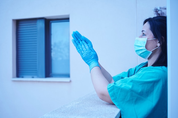 Agent de santé applaudissant depuis le balcon