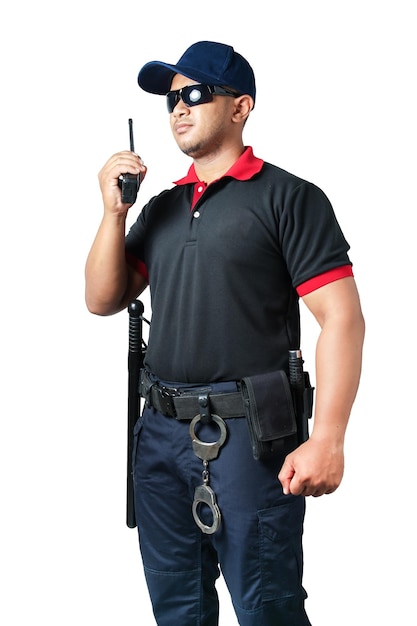 L'agent de sécurité porte des lunettes noires et porte un chapeau. tenant un talkie-walkie avec des matraques en caoutchouc prêtes et des menottes sur une ceinture tactique sur un fond blanc isolé Éliminer le concept de sécurité