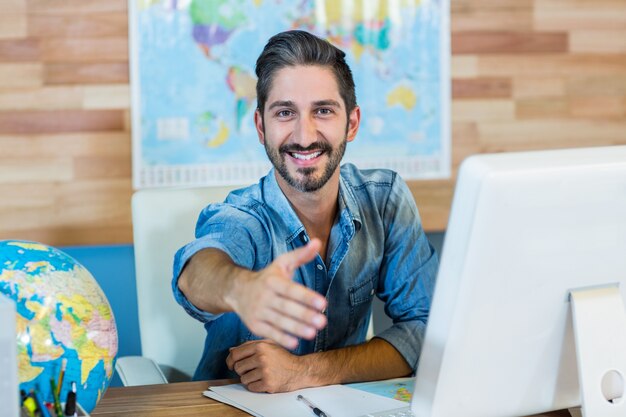 Agent de voyages souriant présentant sa main